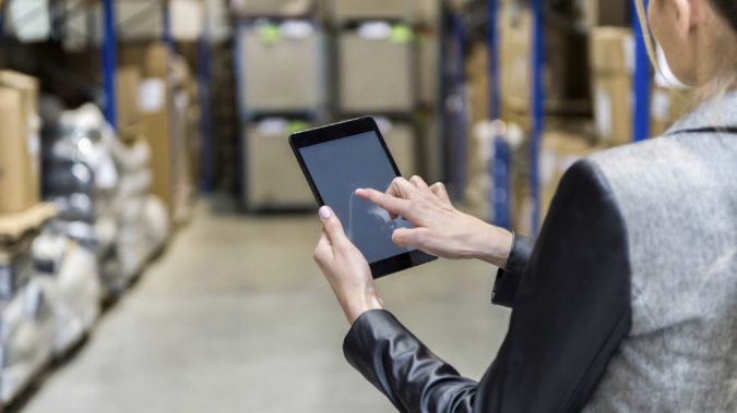 Manager touching tablet screen in warehouse