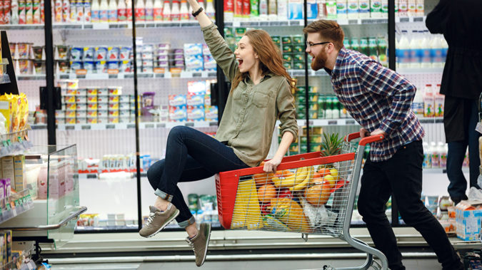 Beautiful couple having fun while choosing food in the supermarket